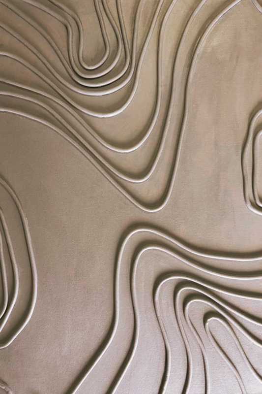 Close-up of a textured surface with wavy, beige patterns